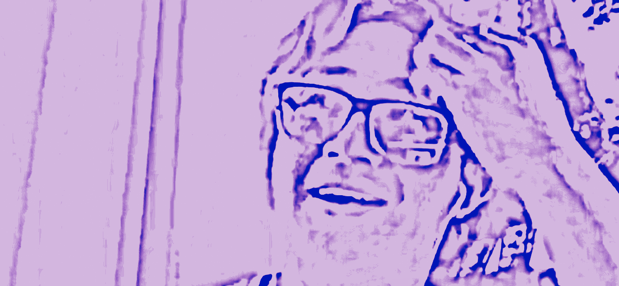 Purple and blue duotone of Sean Martinez in glasses, smiling with his hand touching his forehead.